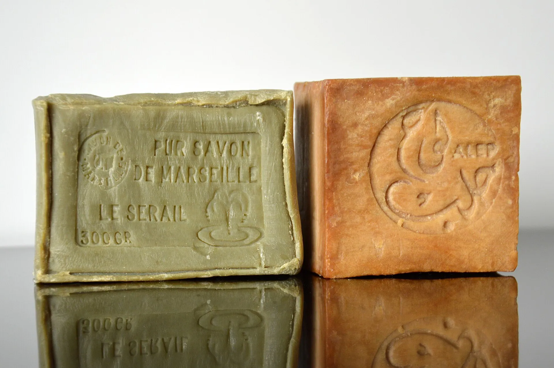 Deux pains de savon de Marseille sur une surface brillante